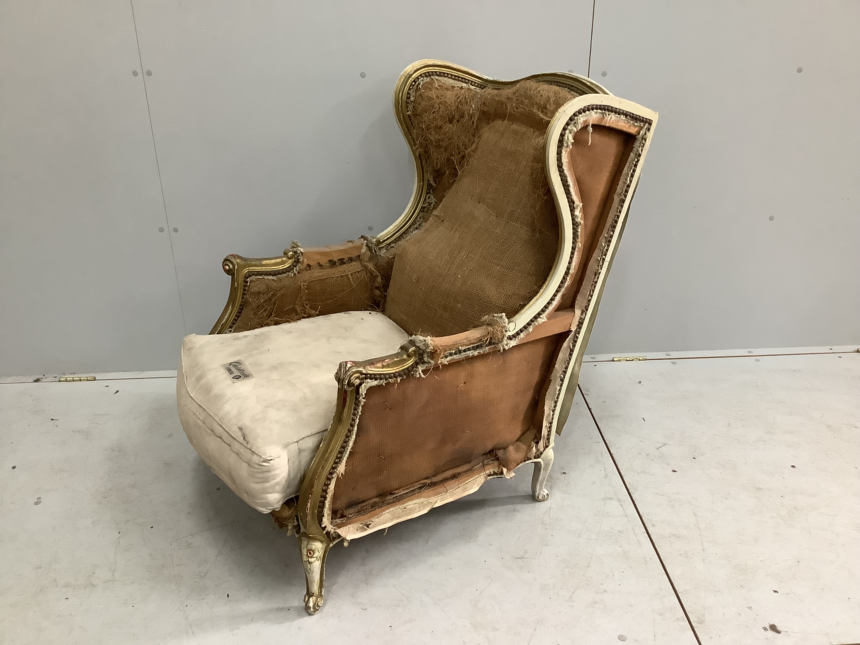 A 19th century French painted parcel gilt armchair requiring re-upholstery, width 69cm, depth 84cm, height 94cm